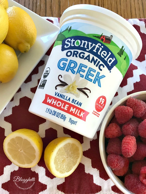 Stonyfield Greek Yogurt with a plate of lemons and a bowl of raspberries