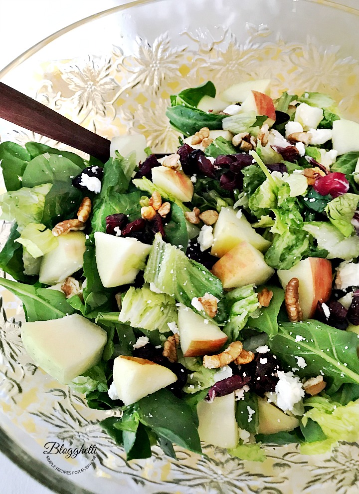 Crystal salad bowl filled with apple cranberry pecan and spinach salad