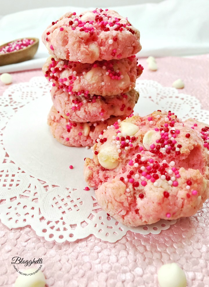 strawberry cheesecake cookies with white chocolate stacked on a white doily