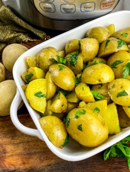 buttered potatoes with parsley in white casserole dish and Instant Pot in background
